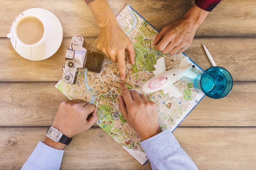 Planes culturales en Villajoyosa en invierno: museos, arte y vida local 1 vista elevada de dos personas que miran el mapa con una taza de te en el escritorio de madera