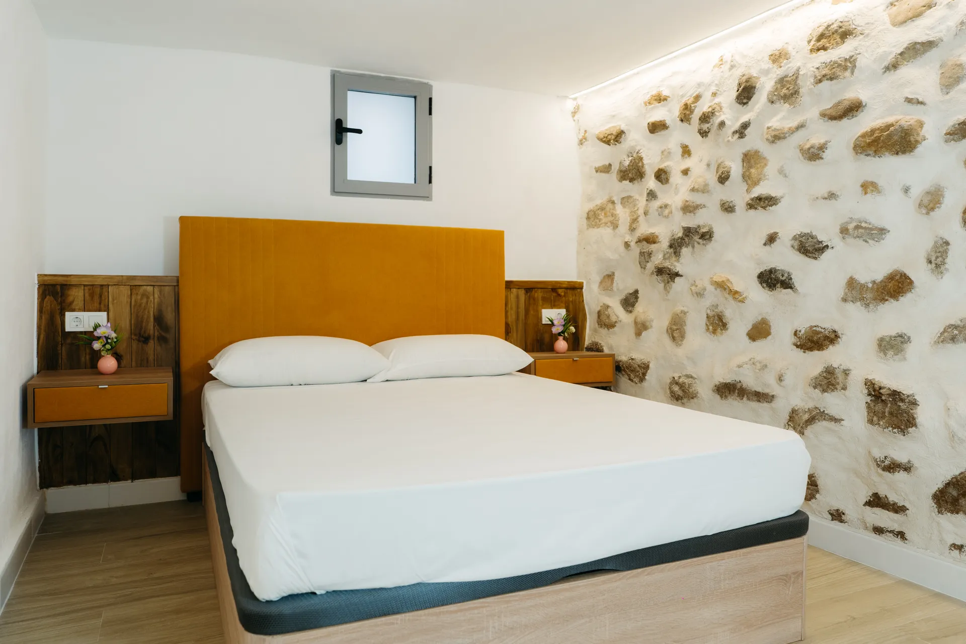 Courbu - Dormitorio con pared de piedra